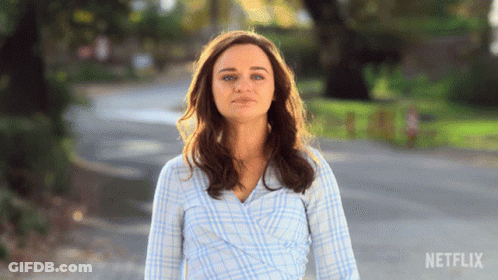 A Woman In A Plaid Shirt Is Walking Down A Street With Netflix Written On The Bottom Right GIF