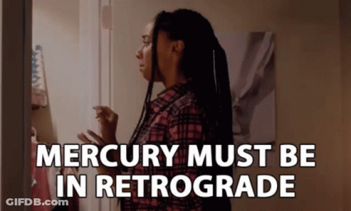 A Woman In A Plaid Shirt Stands In Front Of A Door With The Words " Mercury Must Be In Retrograde " GIF