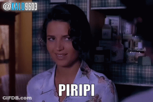 A Woman In A Plaid Shirt With The Word Piripi On Her Chest GIF