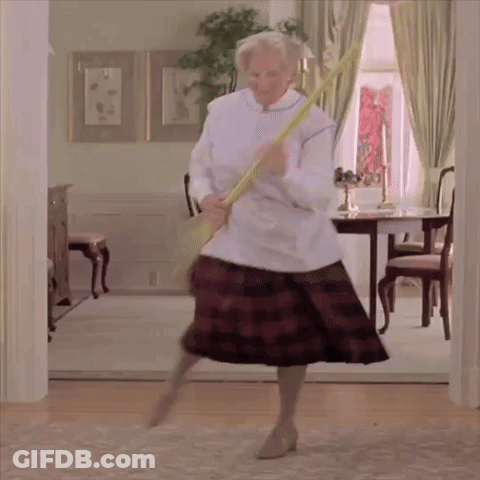 A Woman In A Plaid Skirt Is Holding A Broom In Her Hand GIF