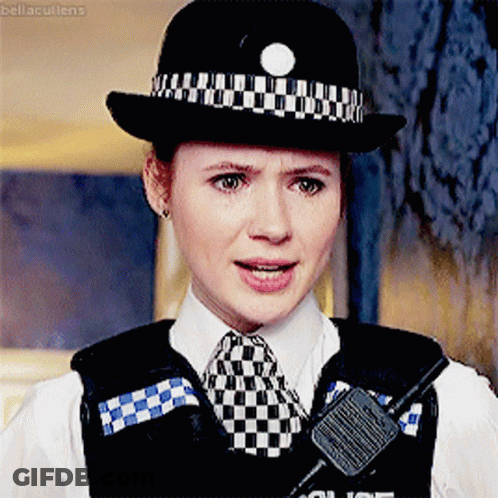 A Woman In A Police Uniform Has A Walkie Talkie On Her Vest GIF
