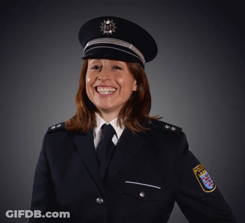 A Woman In A Police Uniform Is Smiling And Wearing A Badge That Says Police GIF