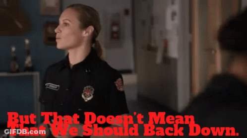 Police Woman Standing In Front Of Back Down Sign GIF