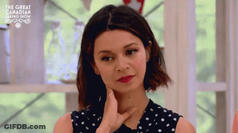 A Woman In A Polka Dot Dress Is Making A Funny Face With Her Hand On Her Chin . GIF