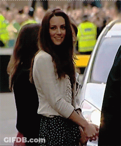 A Woman In A Polka Dot Skirt Smiles While Standing Next To A Car GIF