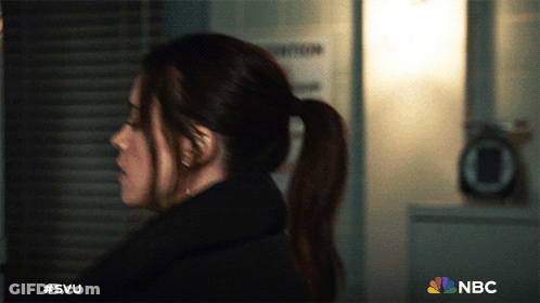 A Woman In A Ponytail Is Standing In Front Of A Sign That Says Nbc GIF