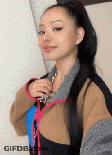 A Woman In A Ponytail Takes A Selfie With Her Phone GIF
