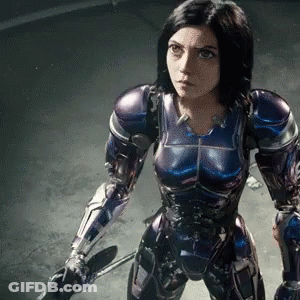 A Woman In A Purple And Blue Armor Holds A Sword GIF