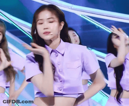 A Woman In A Purple Crop Top Is Dancing On A Stage GIF