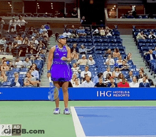 A Woman In A Purple Dress Is Holding A Tennis Racquet GIF