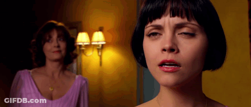 A Woman In A Purple Dress Is Making A Face While Another Woman Looks On GIF