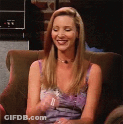 A Woman In A Purple Dress Is Sitting In A Chair And Smiling GIF