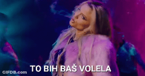 A Woman In A Purple Fur Coat Is Dancing In Front Of A Purple And Blue Background . GIF