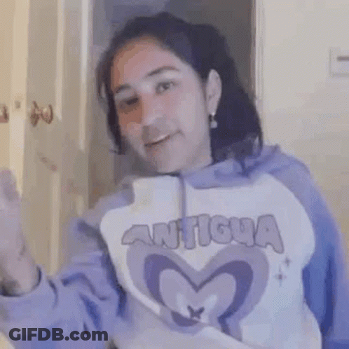 A Woman In A Purple Hoodie Is Smiling And Holding A Knife In Her Hand . GIF