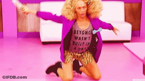 A Woman In A Purple Jacket And Leopard Print Shorts Is Kneeling On The Floor Holding A Broom . GIF