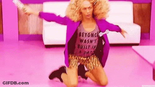 A Woman In A Purple Jacket And Leopard Print Shorts Is Kneeling On The Floor In A Room . GIF