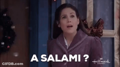 A Woman In A Purple Jacket Is Standing In Front Of A Door And Smiling . GIF