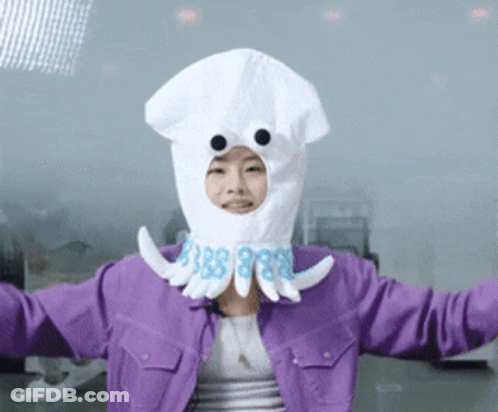 A Woman In A Purple Jacket Is Wearing A White Squid Costume GIF
