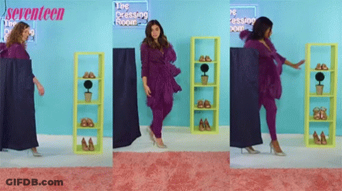 A Woman In A Purple Outfit Is Standing In Front Of A Sign That Says Seventeen GIF