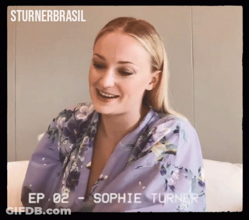A Woman In A Purple Robe Is Smiling In A Video From Sturner Brasil GIF