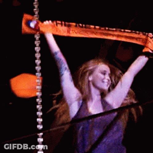 A Woman In A Purple Shirt Is Holding A Scarf In Her Hands GIF