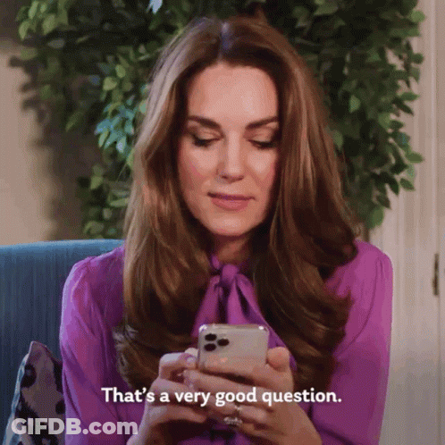 A Woman In A Purple Shirt Is Looking At Her Cell Phone And Says That 'S A Very Good Question GIF