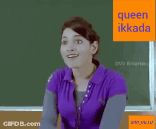 A Woman In A Purple Shirt Is Sitting In Front Of A Green Board With The Words Queen Ikkada On It . GIF