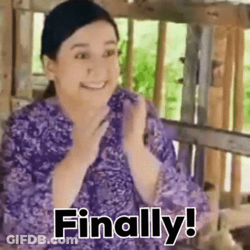 A Woman In A Purple Shirt Is Sitting On A Bench And Smiling . GIF