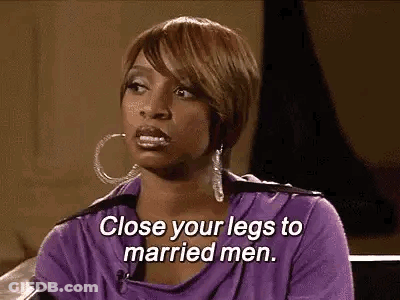 A Woman In A Purple Shirt Is Sitting On A Couch And Talking To A Married Man . GIF
