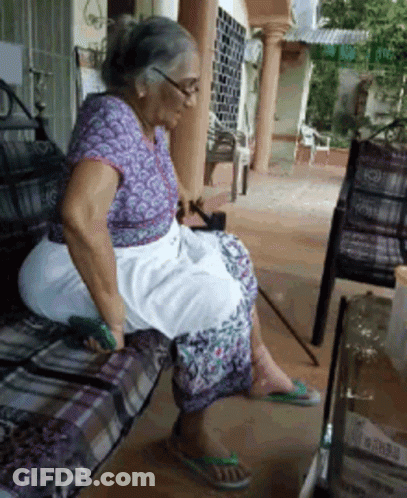 A Woman In A Purple Shirt Sits On A Bench GIF