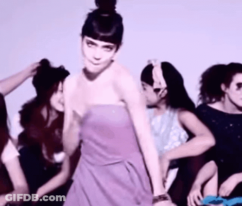 A Woman In A Purple Strapless Dress Is Dancing With Other Women GIF