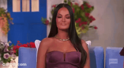 A Woman In A Purple Strapless Dress Is Sitting In A Chair . GIF