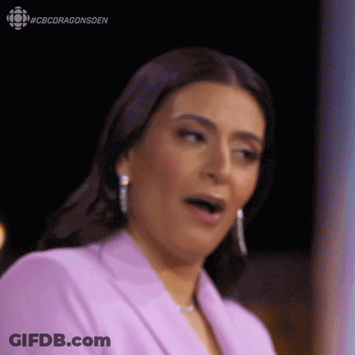 A Woman In A Purple Suit Is Making A Funny Face . GIF