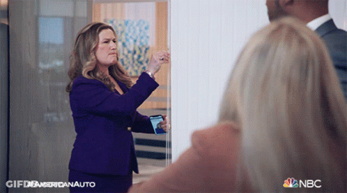 Woman In Purple Suit Taking Photo With NBC Logo GIF
