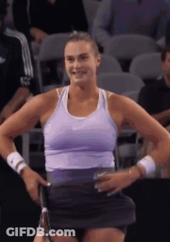 A Woman In A Purple Tank Top Is Holding A Tennis Racquet GIF