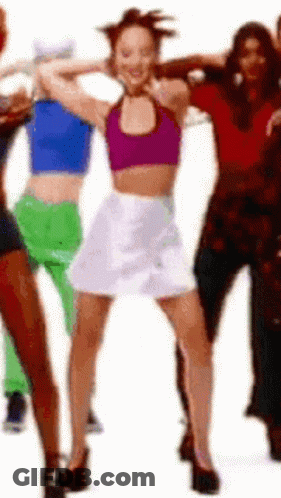 Woman In Purple Top And White Skirt Dancing With Group GIF