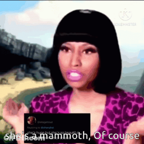 A Woman In A Purple Top Is Holding A Card That Says She 'S Mammoth Of Course GIF