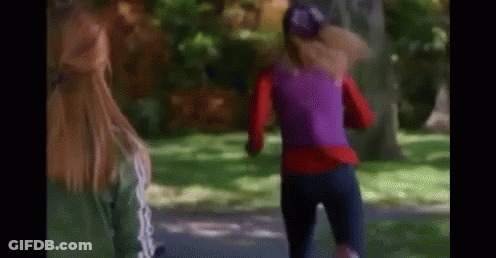 A Woman In A Purple Top Is Running In A Park While Another Woman Watches . GIF