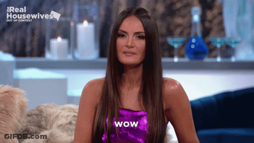 A Woman In A Purple Top With Wow Written On It GIF