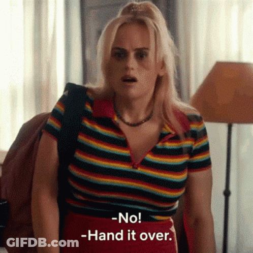 A Woman In A Rainbow Striped Shirt Is Standing In A Room . GIF