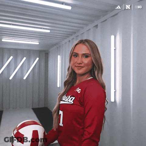 A Woman In A Red Alaska Jersey Holds A Volleyball In Her Hand GIF