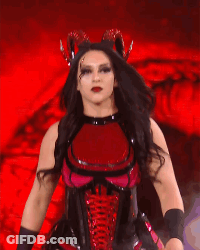 A Woman In A Red And Black Costume Is Dancing GIF