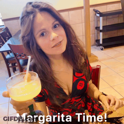 A Woman In A Red And Black Dress Holds A Margarita In Her Hand GIF
