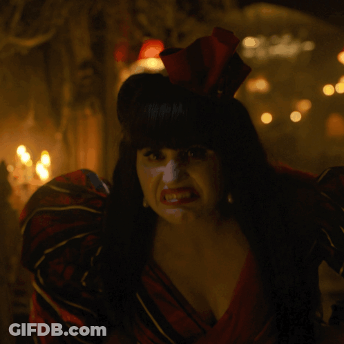 A Woman In A Red And Black Dress With A Red Bow In Her Hair GIF