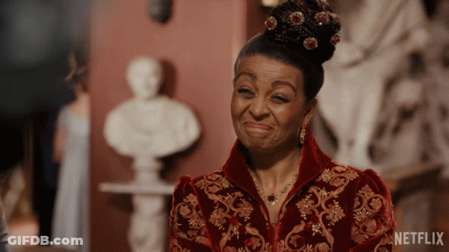 A Woman In A Red And Gold Dress With A Netflix Logo On The Bottom GIF