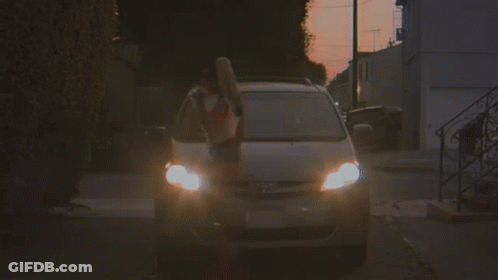 A Woman In A Red And White Crop Top Is Getting Out Of A Car . GIF