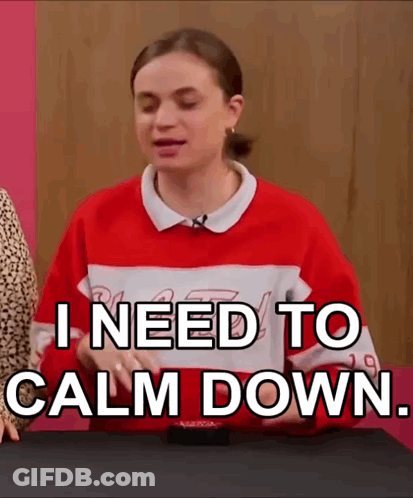 A Woman In A Red And White Sweater Is Sitting At A Table . GIF