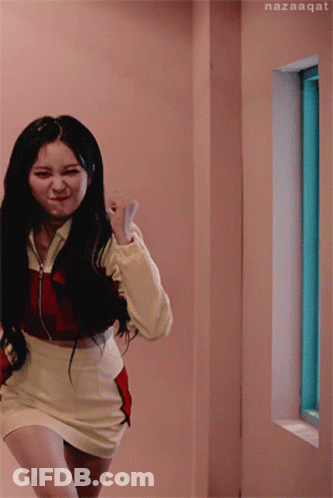 A Woman In A Red And Yellow Outfit Is Running In A Hallway Next To A Window With Nazaaqat Written On The Bottom GIF