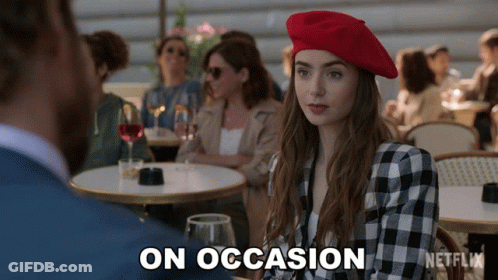A Woman In A Red Beret Sits At A Table With A Netflix Logo On The Bottom GIF