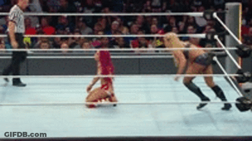 A Woman In A Red Bikini Is Kneeling On The Floor In A Wrestling Ring GIF